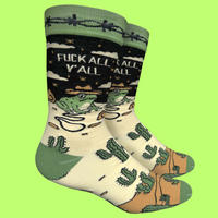 A pair of socks with a frog and desert motif with the slogan F**k All Y'All on the ankle. Green toes, cuff and heel.