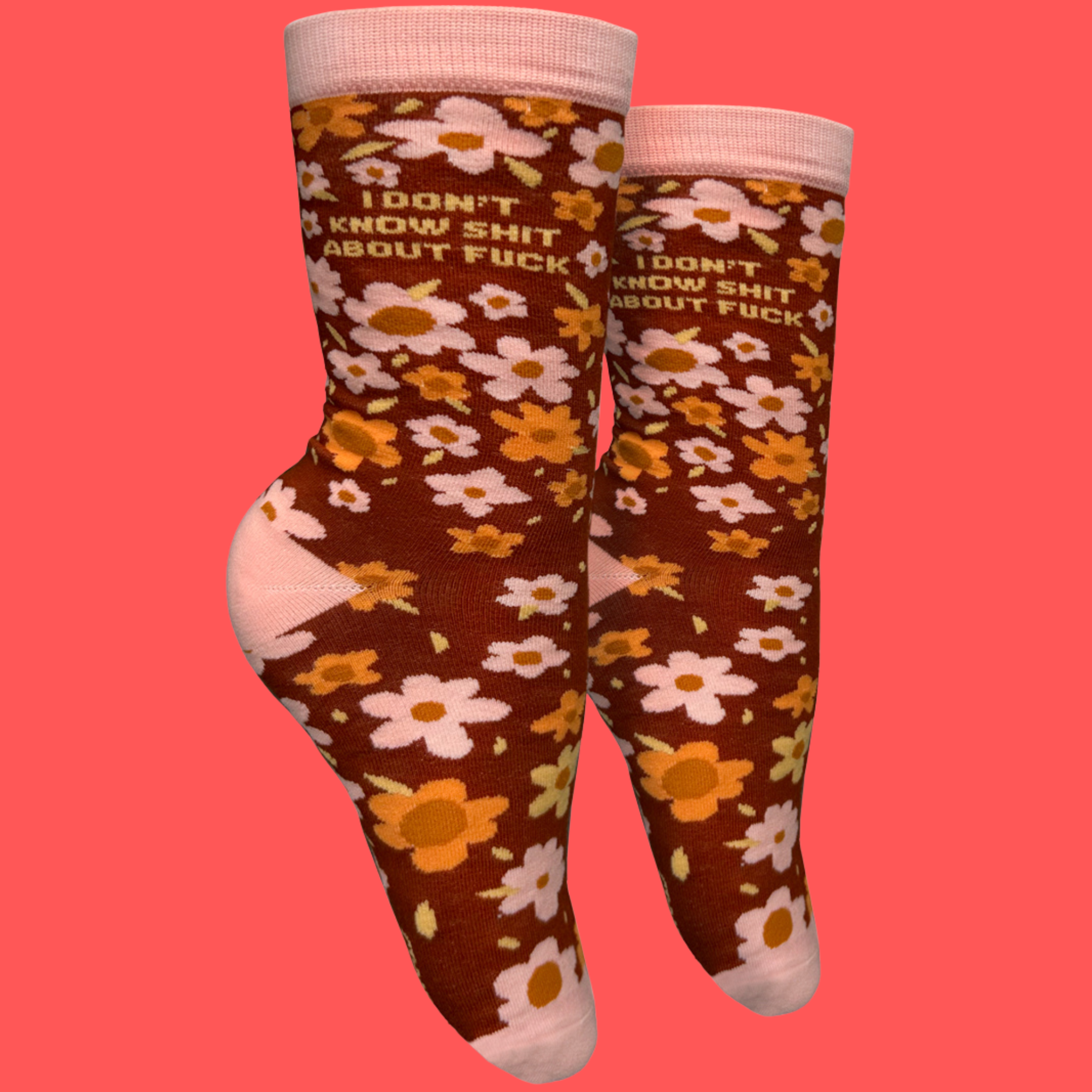 A pair of socks with a bold sweary slogan and a bold flowers design. Pink toes, hell and cuff.