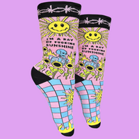 I'm A Ray Of F**king Sunshine Socks - Small. A pair of socks with a psychedelic sun shine pattern in bright blue and pink. Black toes, heel and cuff.