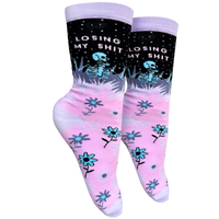 A pink and purple pair of socks with a skeleton and the slogan Losing My S**t on the ankle. Pink heel, toe and cuff.