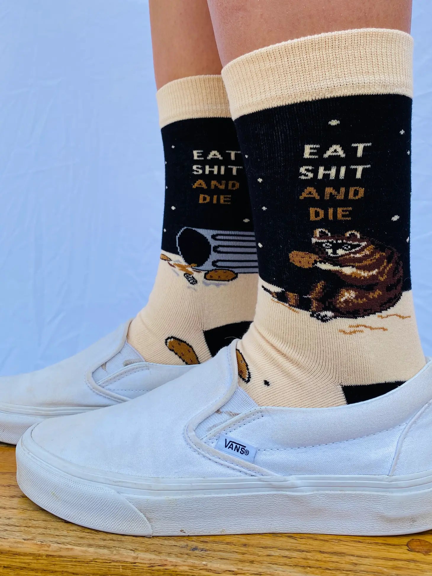 Model wearing a pair of socks with a bold slogan and racoon eating out of the bin detail. Black toe, cuff and heel.