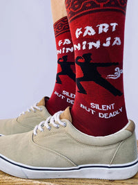 A model wearing a pair of socks depicting a ninja doing a massive fart! Red and pink details with purple toes, heel and cuff.