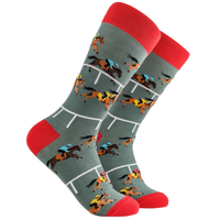 A pair of socks depicting horse racing. Grey legs, red cuff and, heel and toe. 
